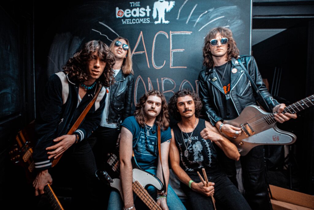 Ace Munroe band members in front of chalk board announcing their band.