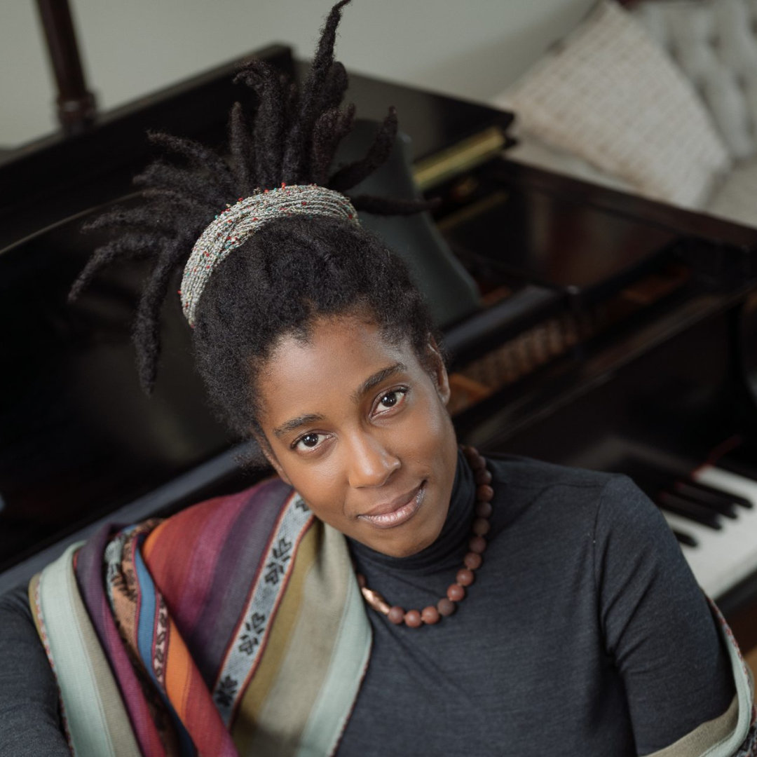 Janelle Gill sitting with her back to piano